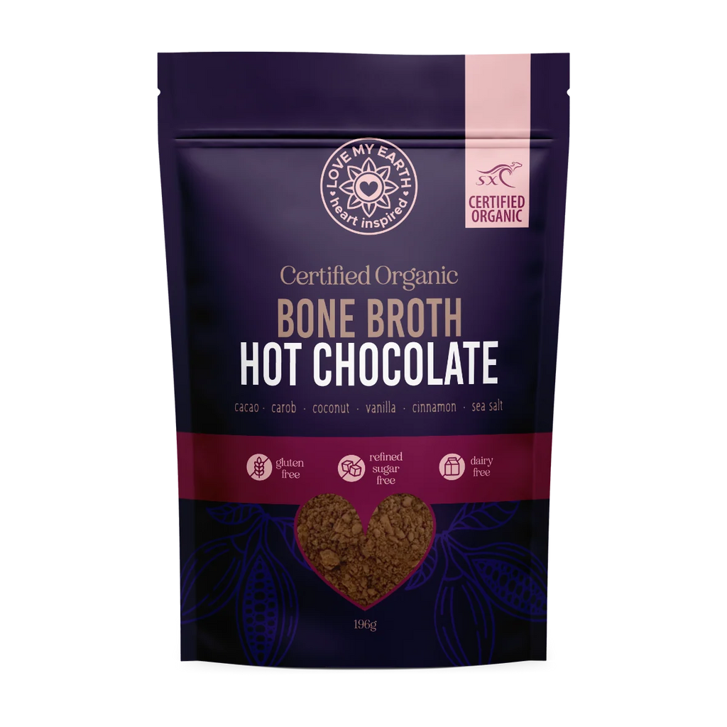 A 196g stand-up pouch of 'Love My Earth' Bone Broth Hot Chocolate, featuring a dark purple and magenta design with a heart-shaped window showing the brown powder inside.